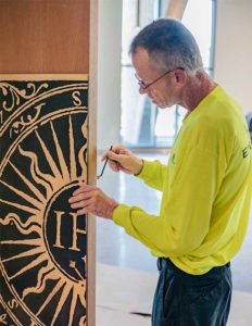 Sign Installer hanging custom door sign from Engraphix