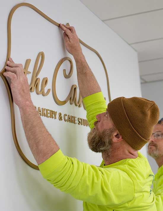 Engraphix Custom Install Team Installing Wall Logo