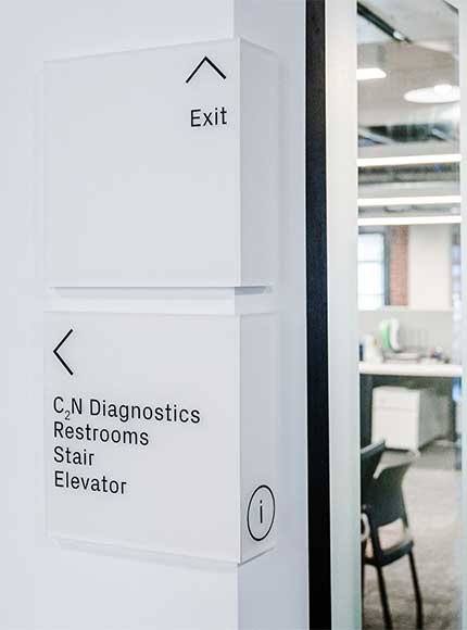 White office directional signs placed on corner