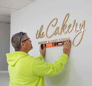 Install crew in yellow leveling gold logo wall dimensional letters