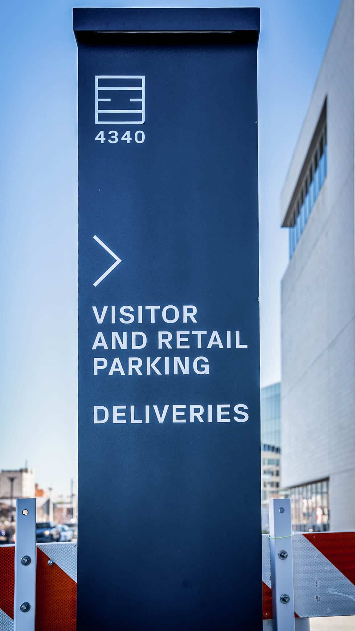 Panel wayfinding sign in blue with BioSTL logo for parking directions