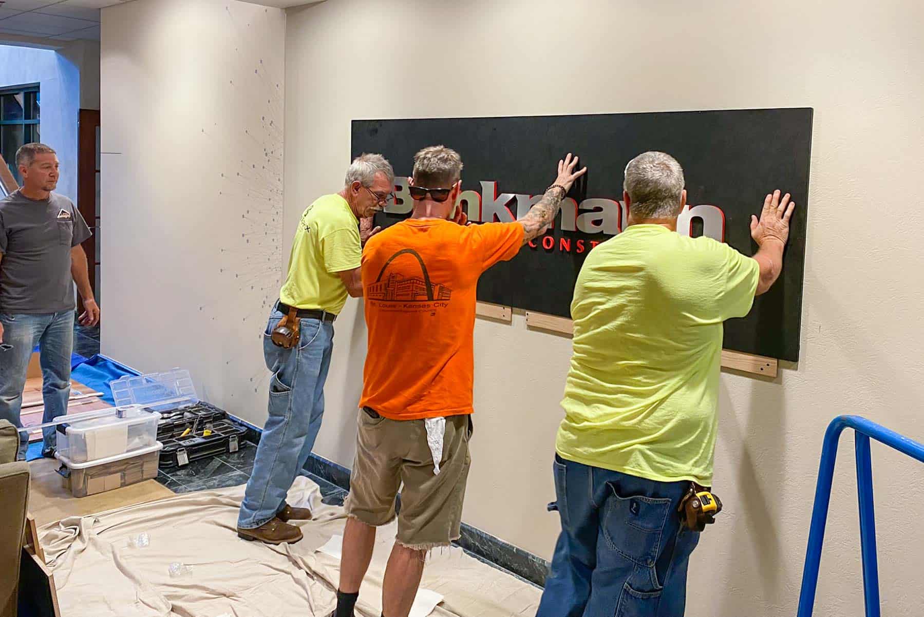 Team installing custom wall logo