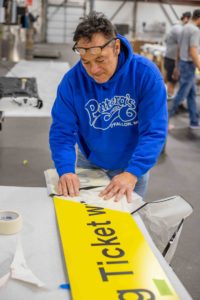 Engraphix Vinyl team preparing yellow parking garage sign