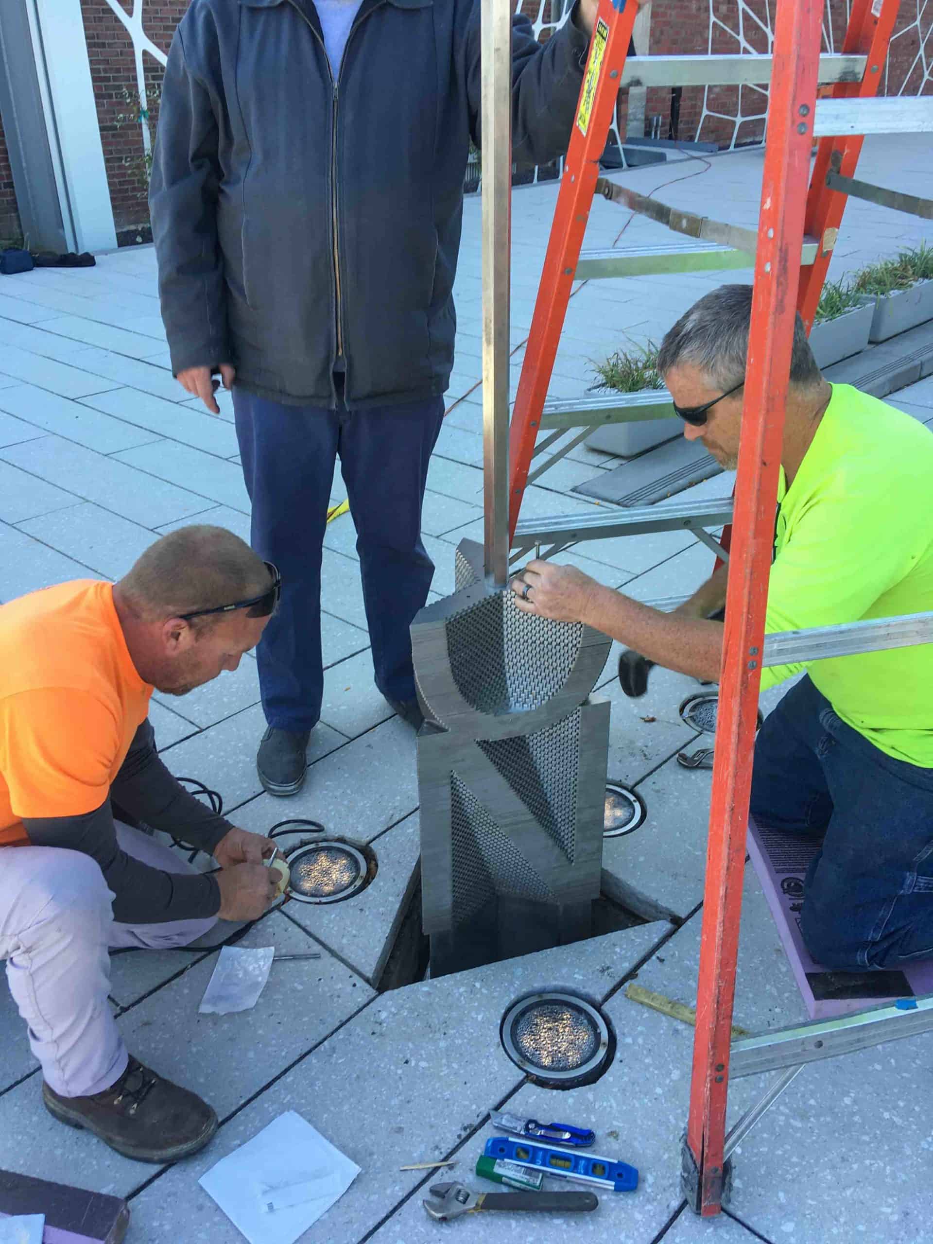 Team custom installing sculptural illusion piece at the Sheldon concert Hall