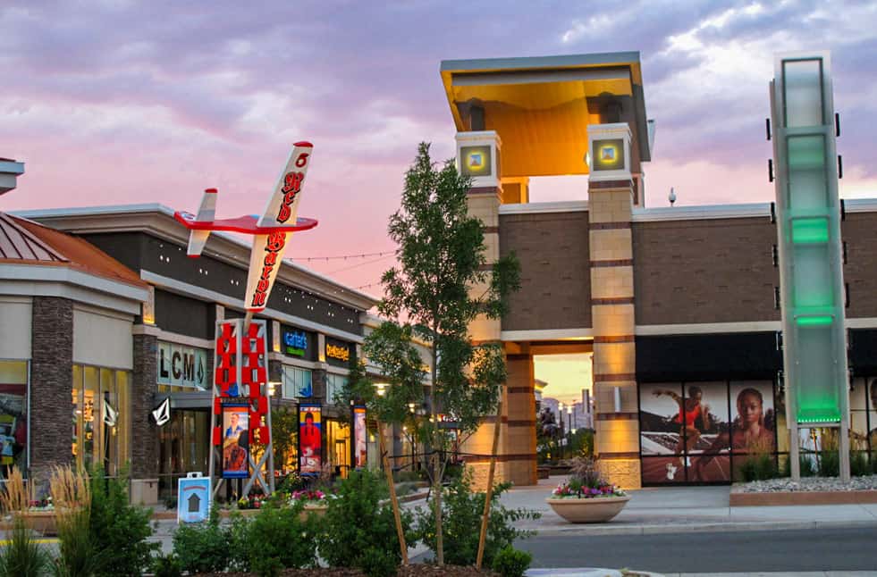 Legends Mall Structural Art with airplane and stores lit up during sunset