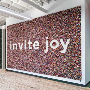 Invite Joy Wall graphic made out of pom poms environmental graphics for office space engraphix