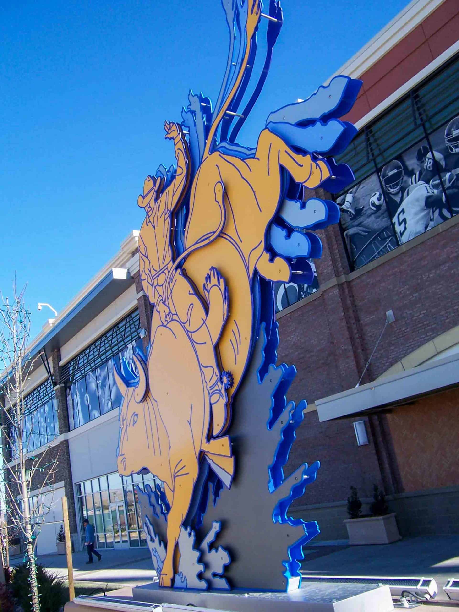 Motion Sculptures of a cowboy riding a bull in yellow and blue