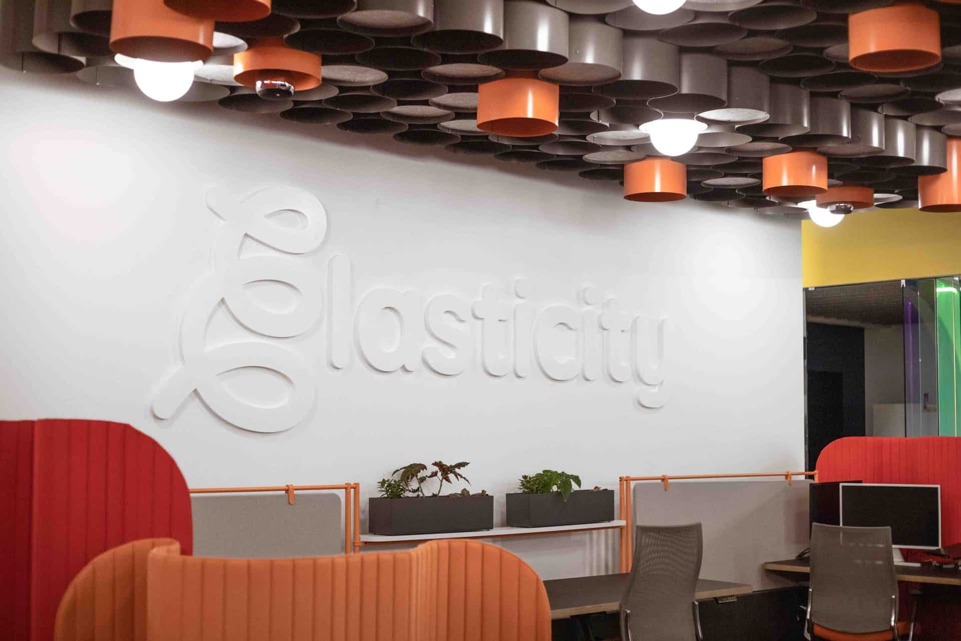 White on white Elasticity logo wall in their colorful office space