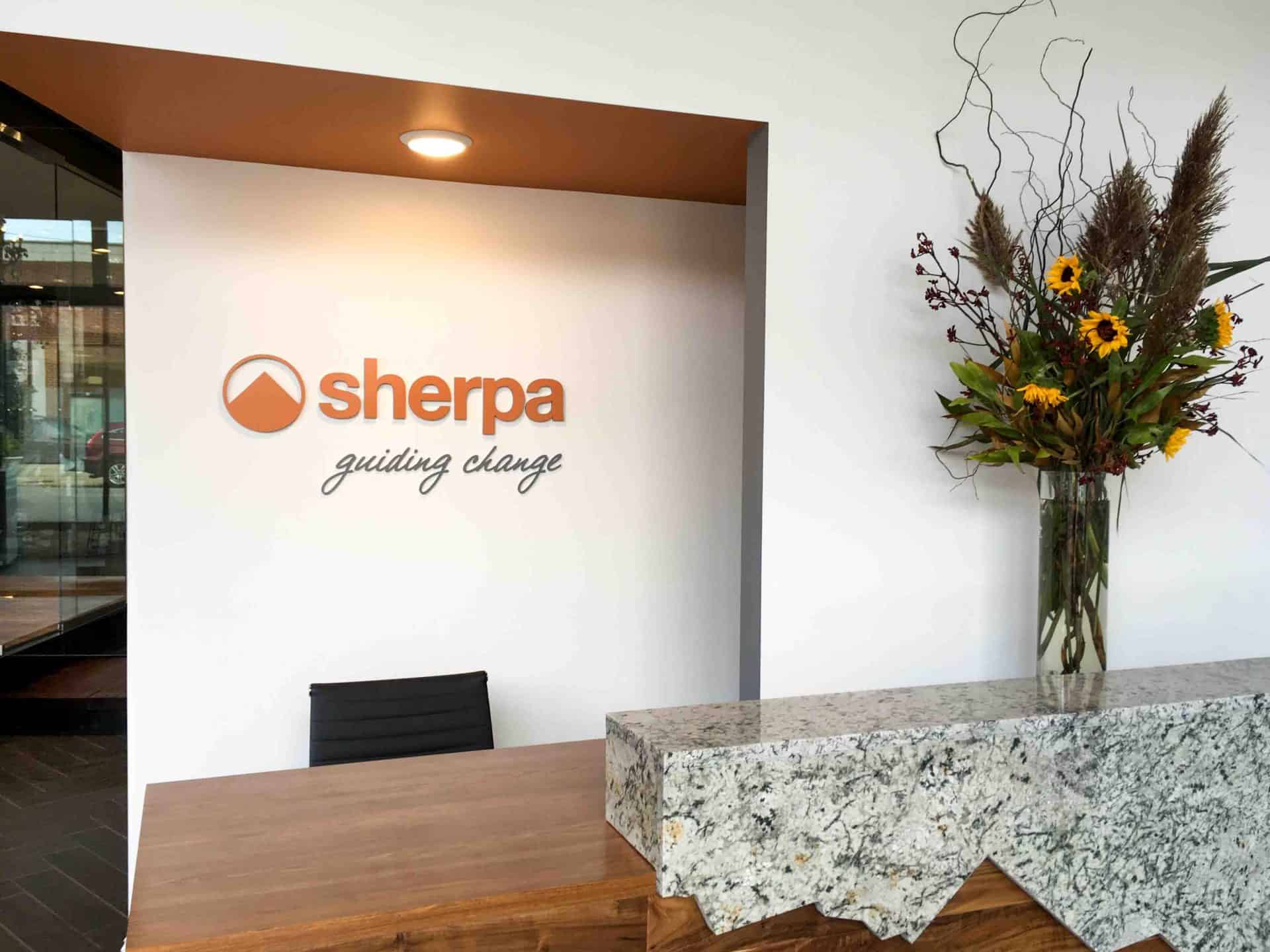 Dimensional logo wall in orange and black for Sherpa