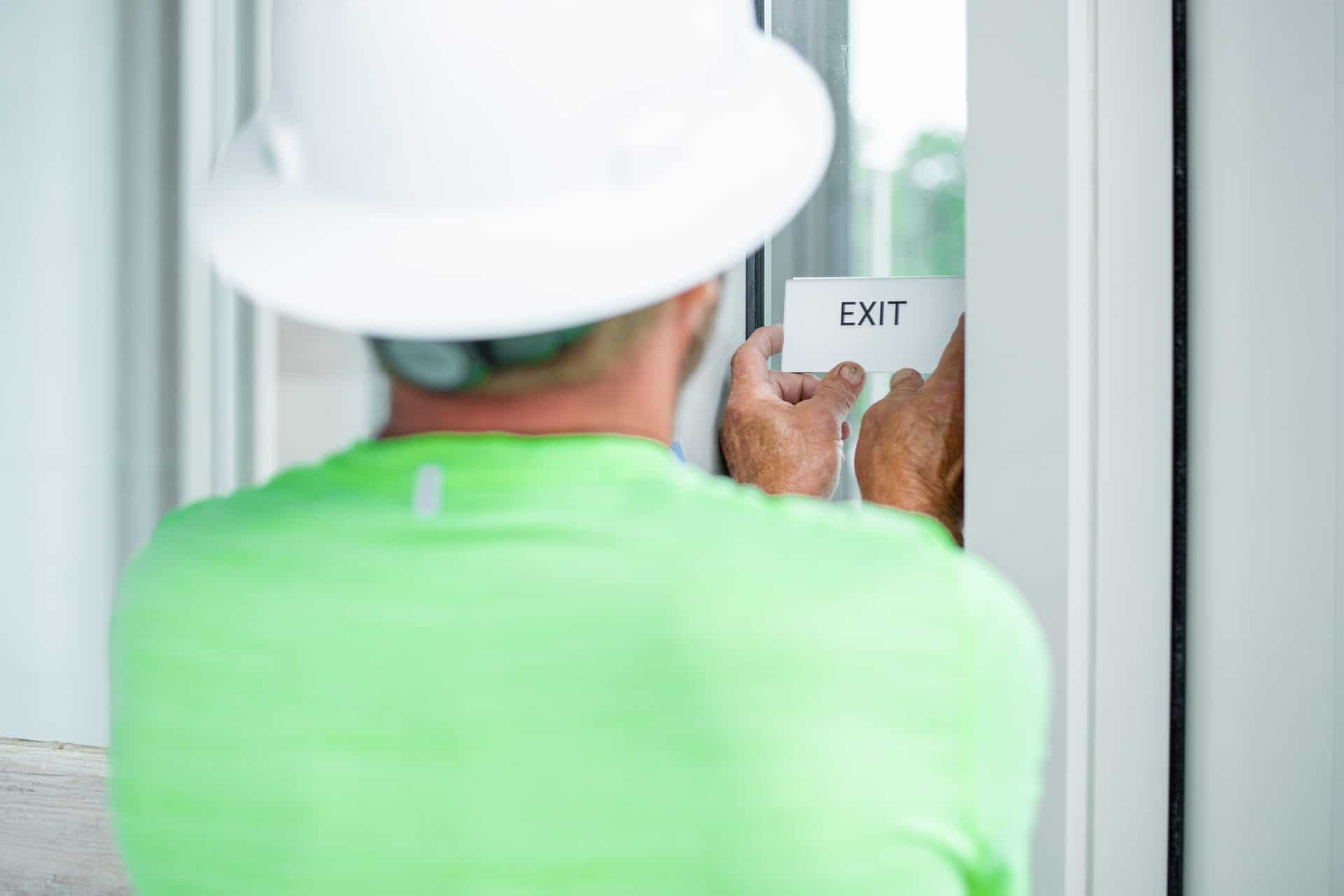 Exit ADA sign for Missouri Botanical Garden Visitor Center white with raised black letters