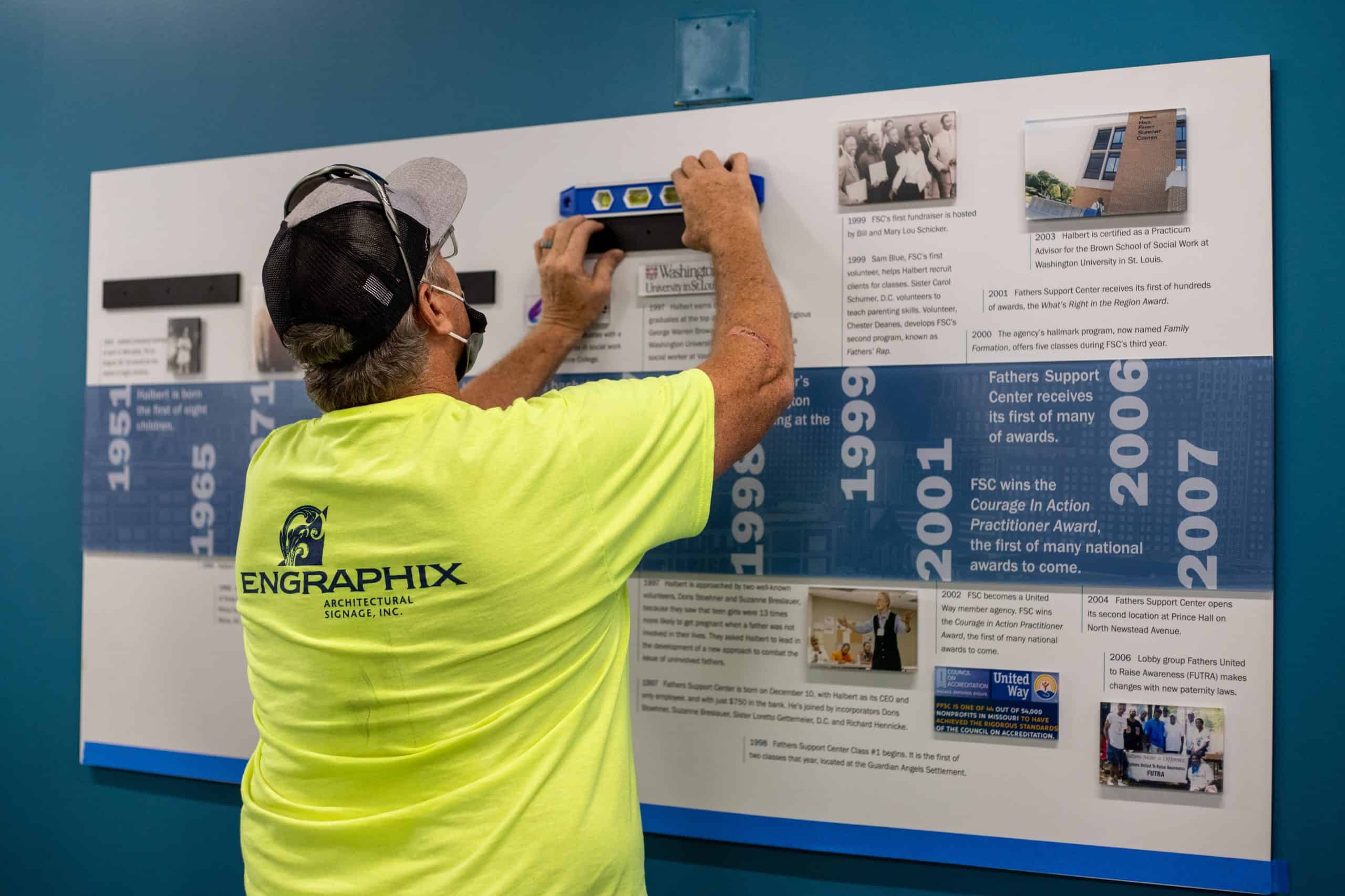 Engraphix team installing custom timeline wall made with dimensional elements