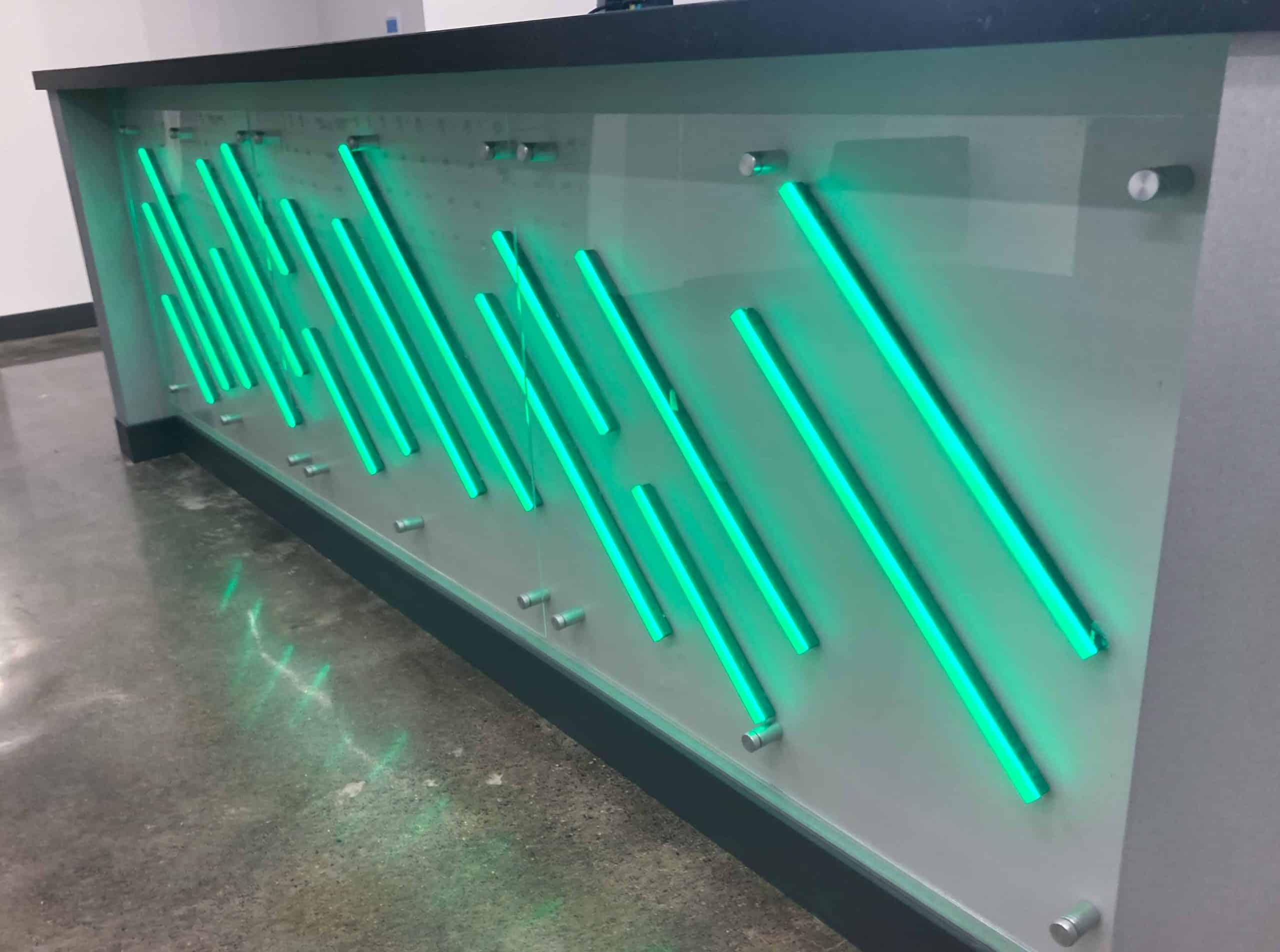 Custom reception desk branding illuminated green neon stripe signs